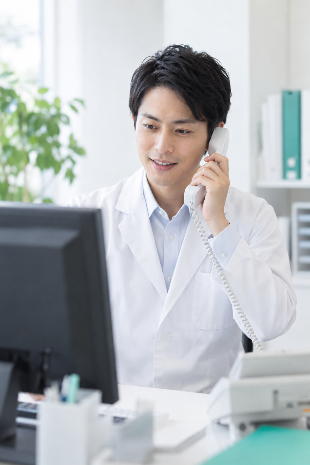 東京ノーストクリニックの男性スタッフが予約確認のお電話をしている様子